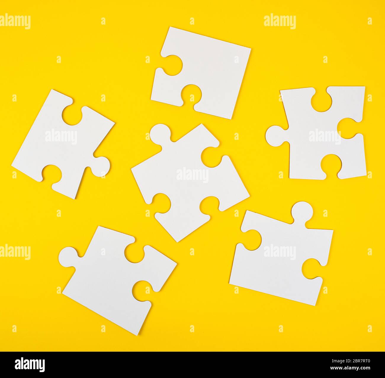 blank white big puzzles on yellow background, flat lay Stock Photo