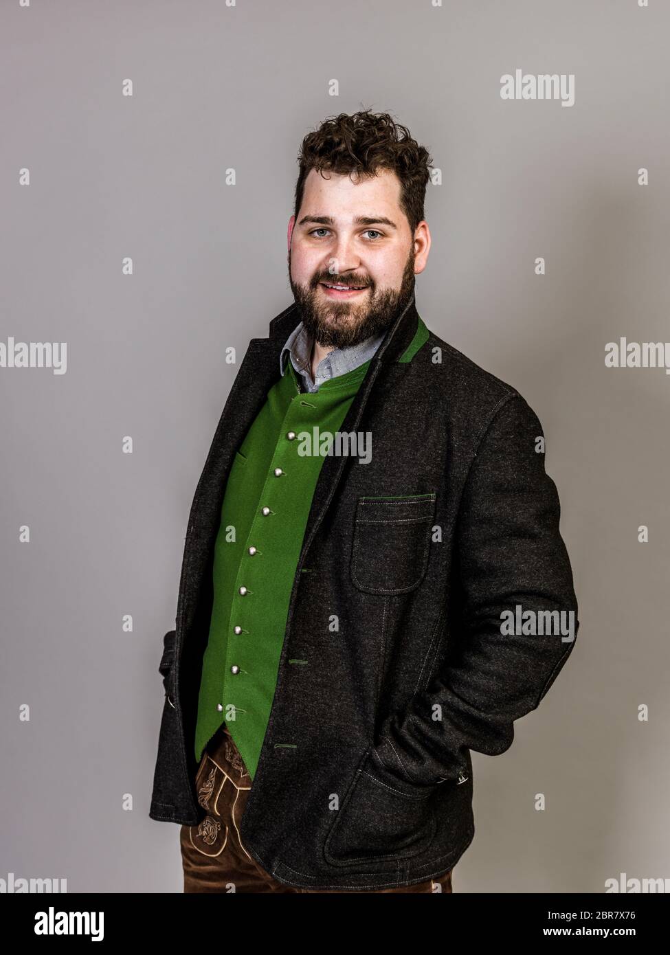 cool man with traditional costume is posing in front of grey background Stock Photo