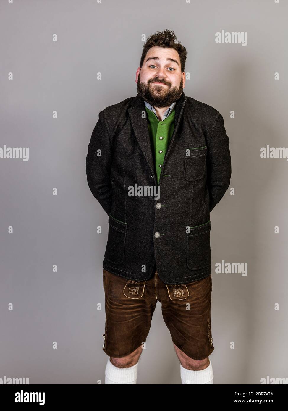 cool man with traditional costume is posing in front of grey background Stock Photo