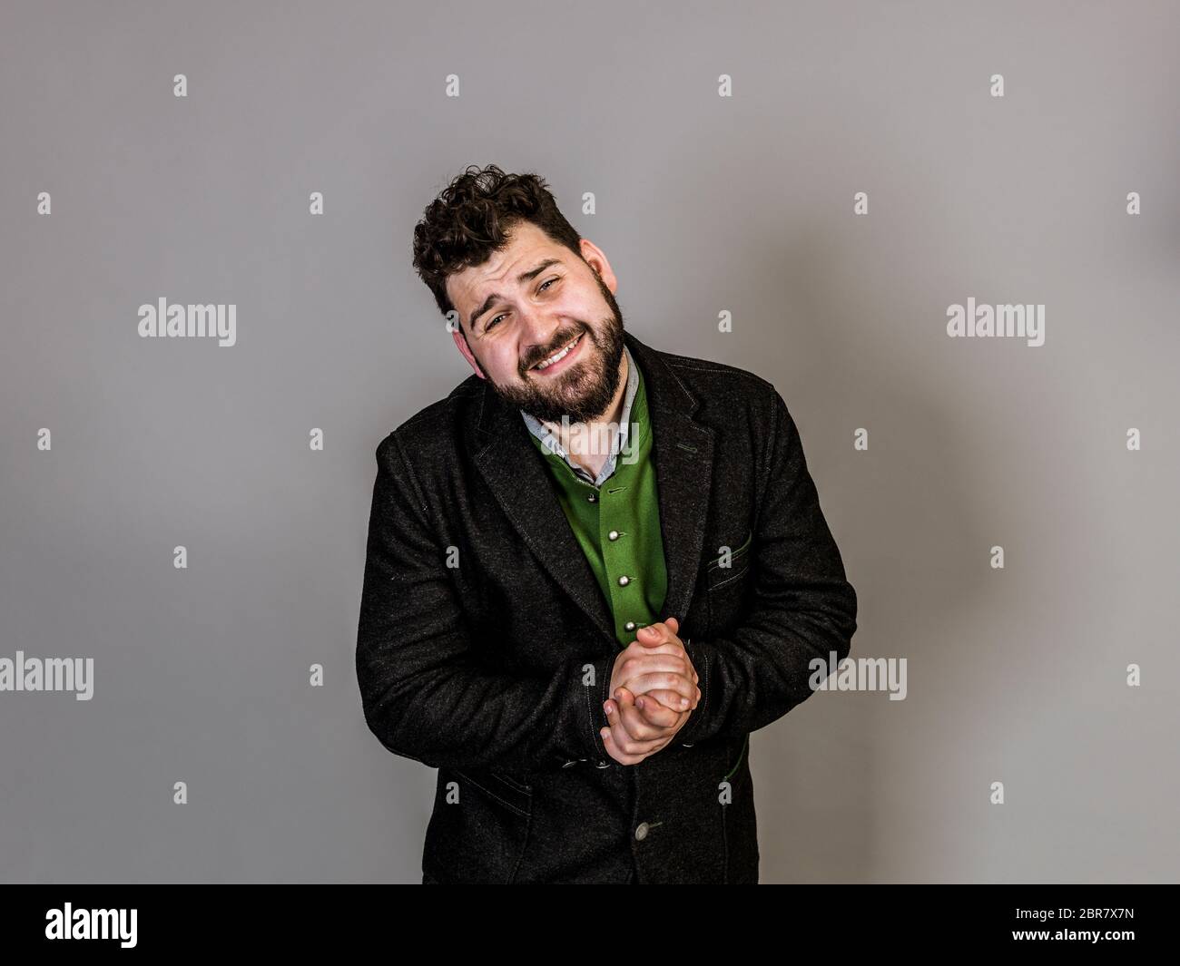 cool man with traditional costume is posing in front of grey background Stock Photo