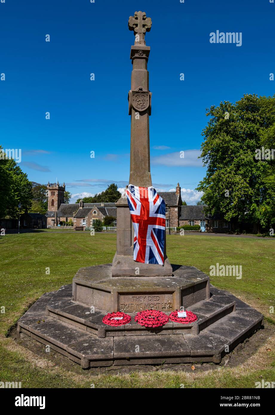 Union Jack flag draped over war memorial on VE day, Dirleton village green, East Lothian, Scotland, UK Stock Photo