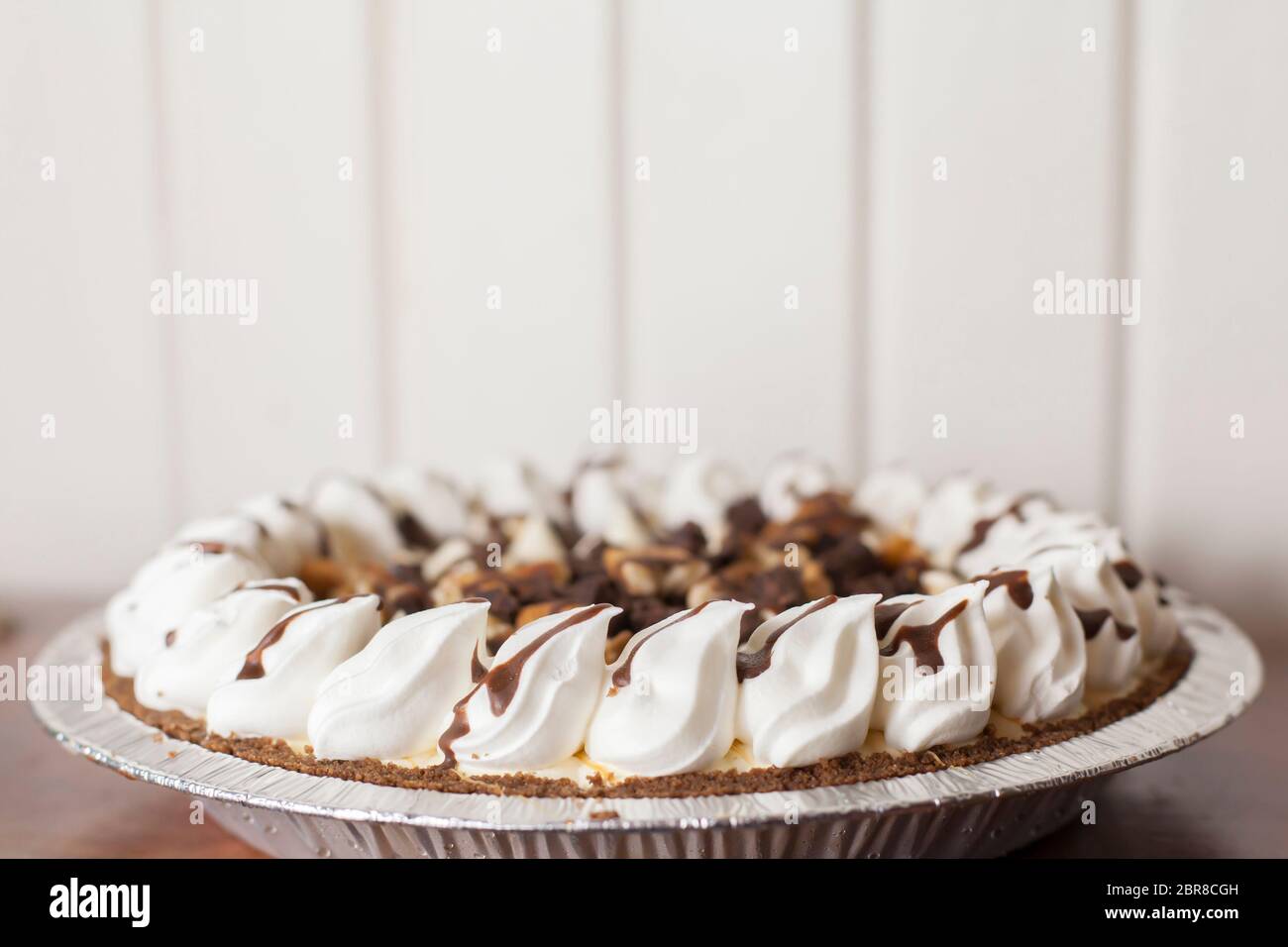 Whole turtle pie with caramel, whipped cream, chocolate and nuts Stock
