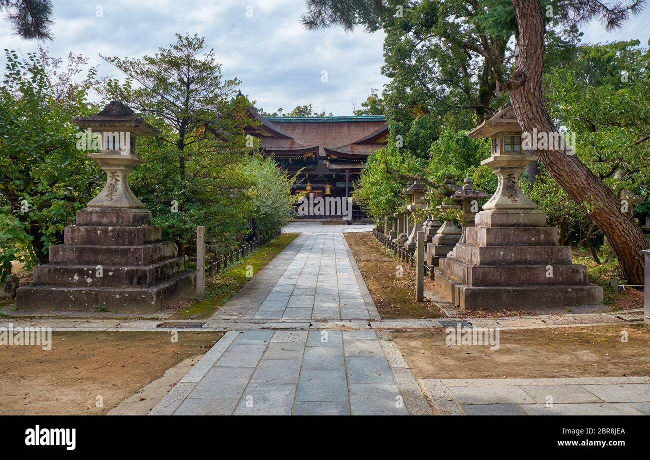The view of the a traditional kaku-doro  (square) stone lanterns standidng along the pass at Kitano Tenmangu shrine. Kyoto. Japan Stock Photo
