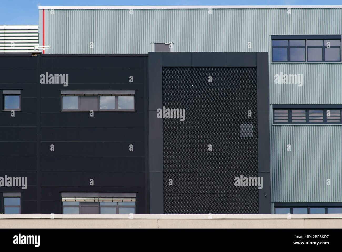 A modern industrial building with various sheet metal facades and grilles. Stock Photo