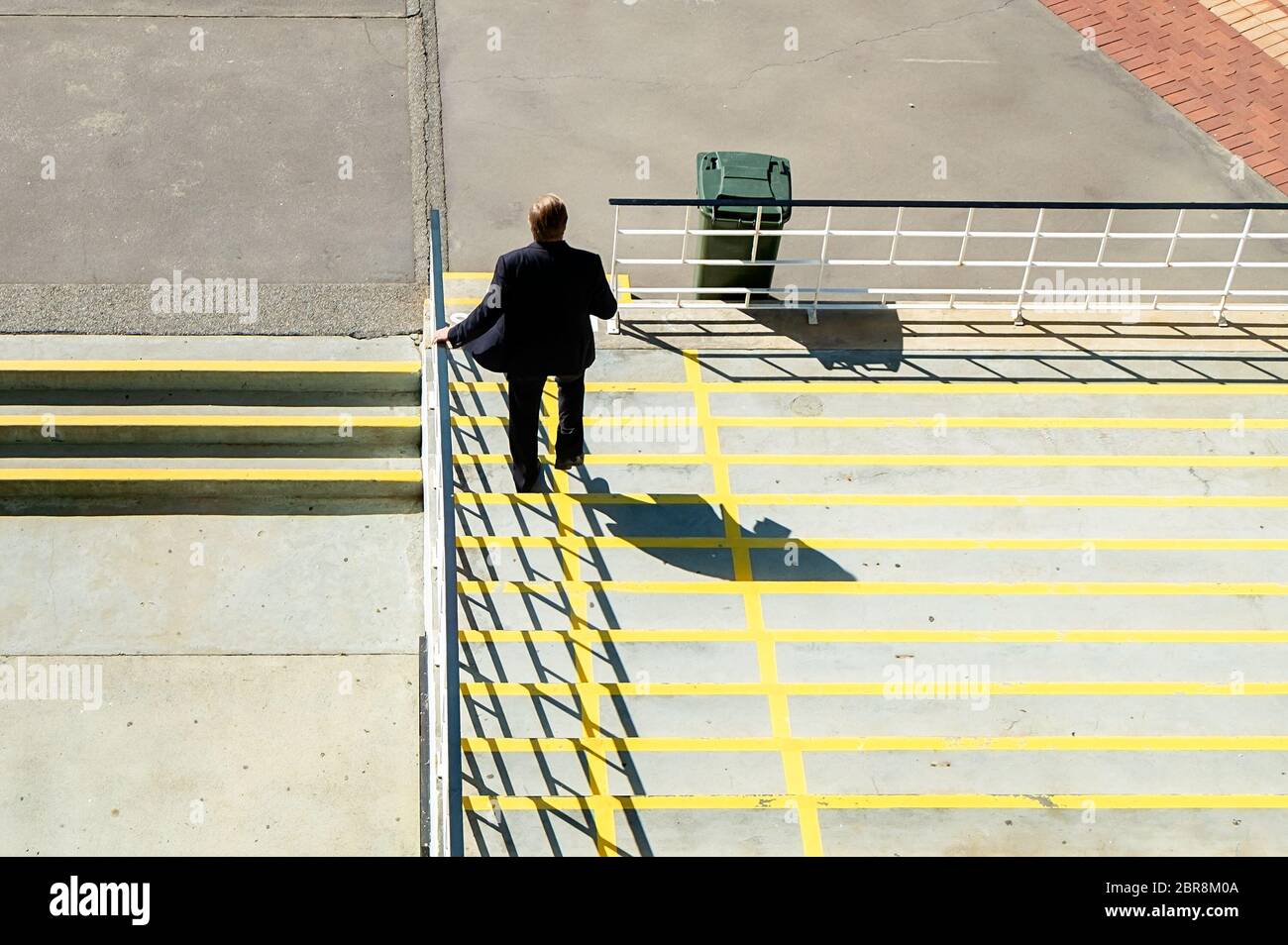 A man in a suit walking down steps. Photo taken from behind looking ...