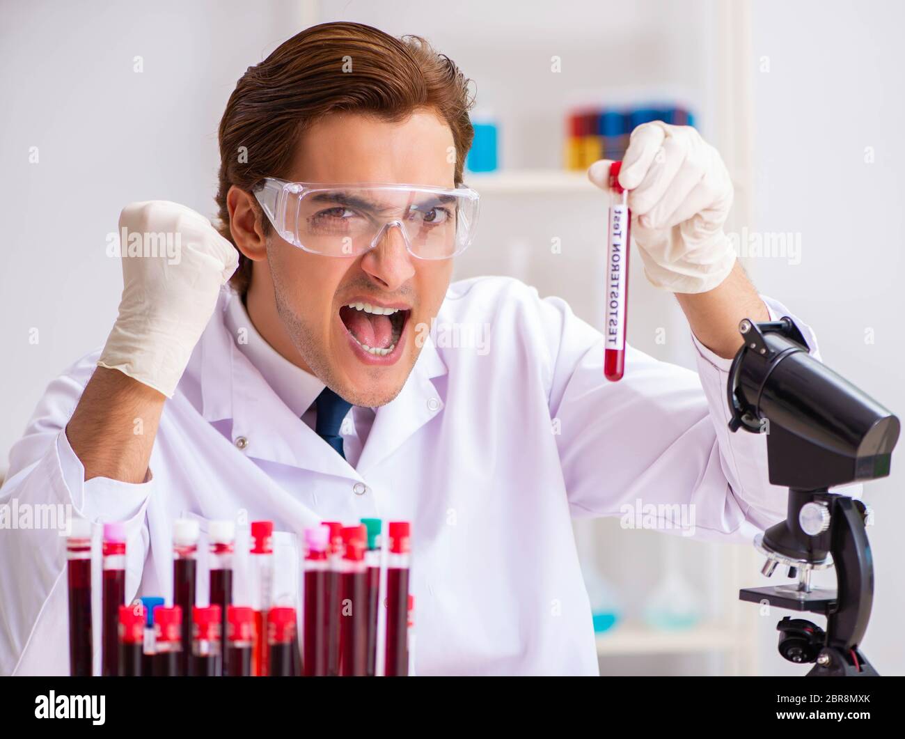 The young handsome lab assistant testing blood samples in hospital