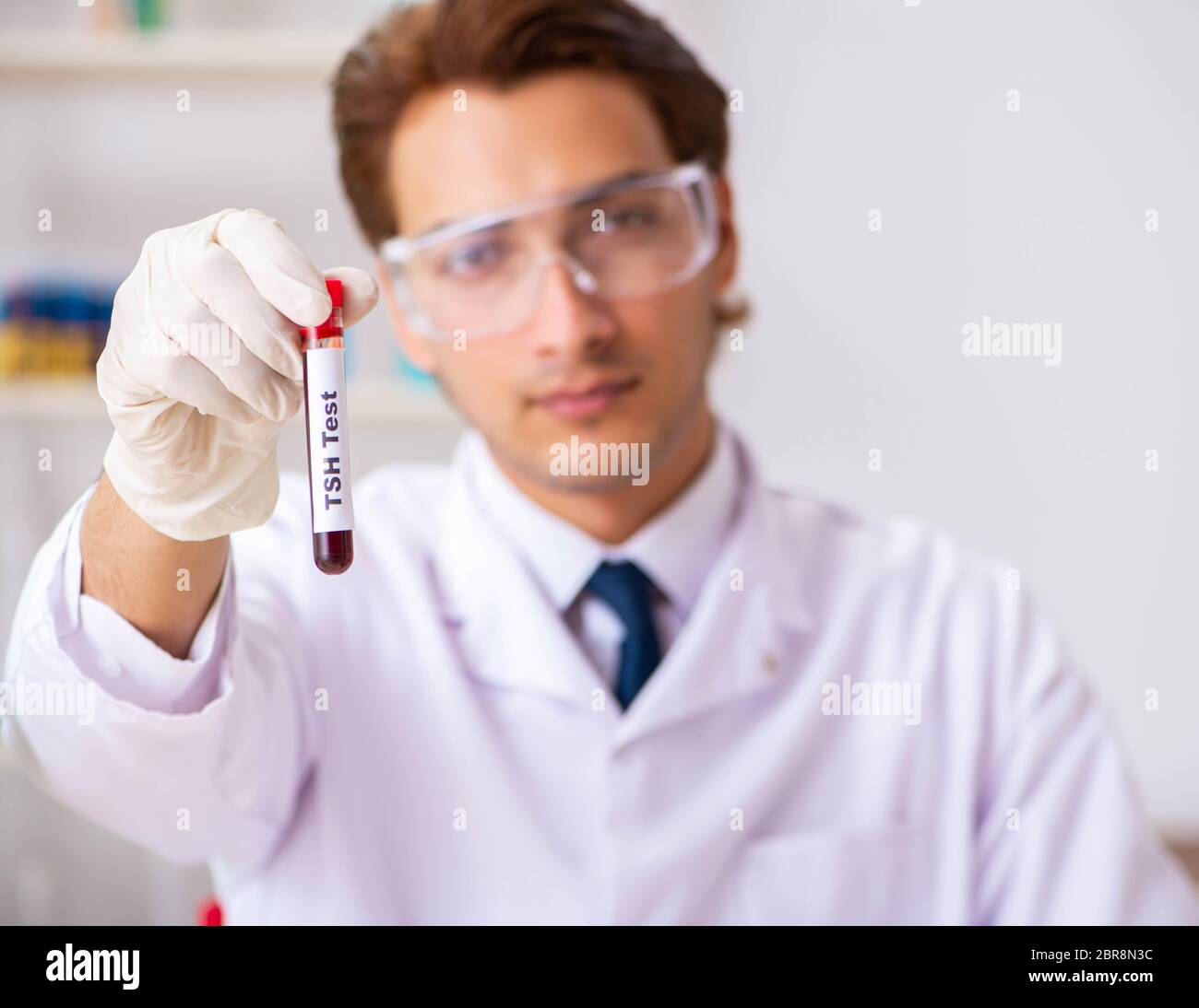 The young handsome lab assistant testing blood samples in hospital
