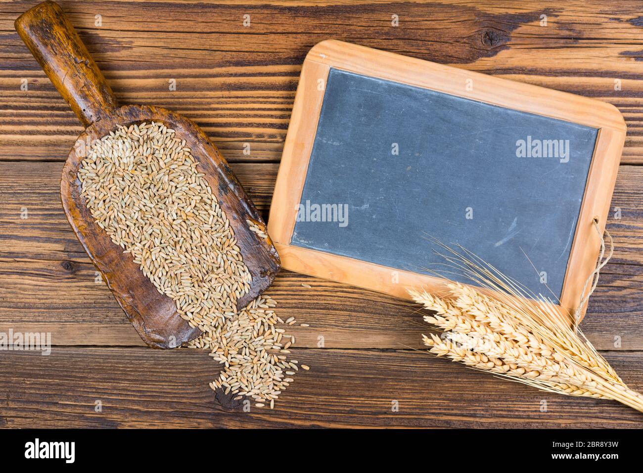 An old slate board, an old flour shovel with grain and ears of grain