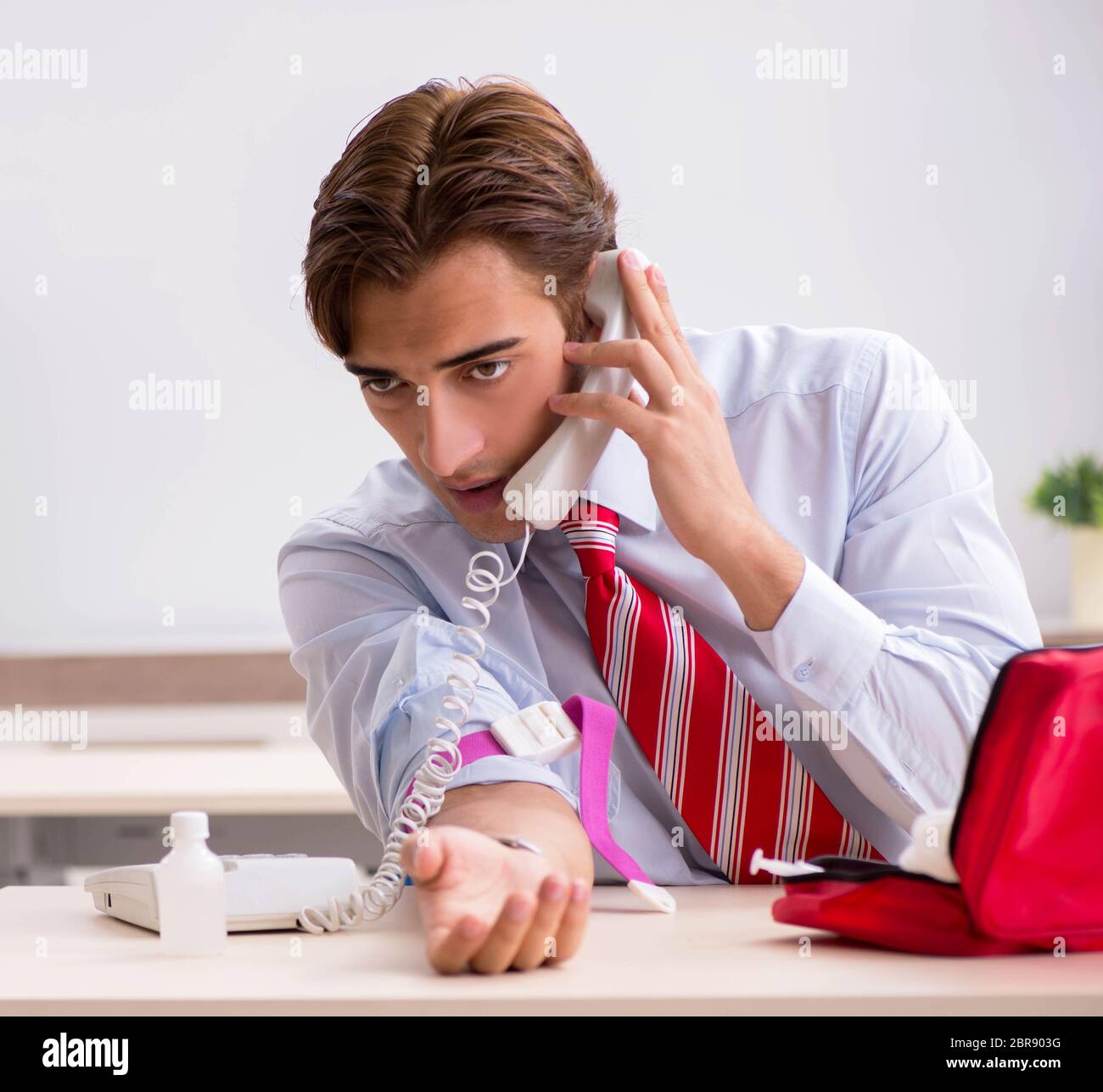The man with first aid kit in the office Stock Photo - Alamy