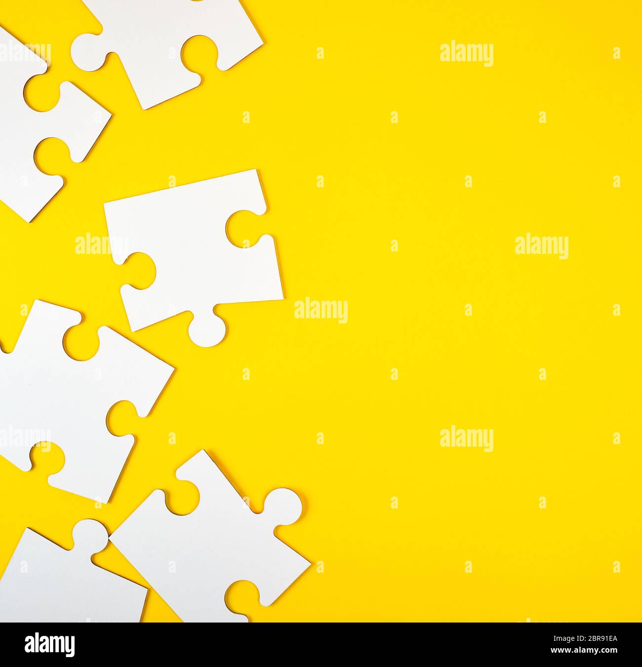 blank white big puzzles on yellow background, flat lay Stock Photo