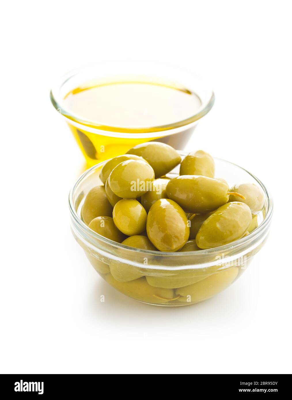 Green olives and olive oil in glass bowl isolated on white background ...