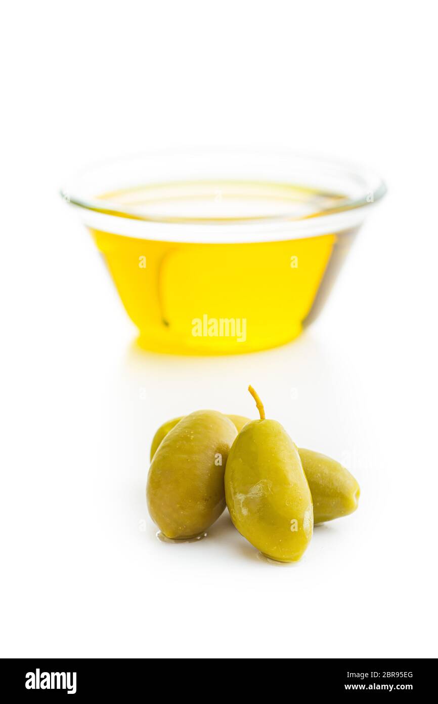 Green olives and olive oil in glass bowl isolated on white background ...