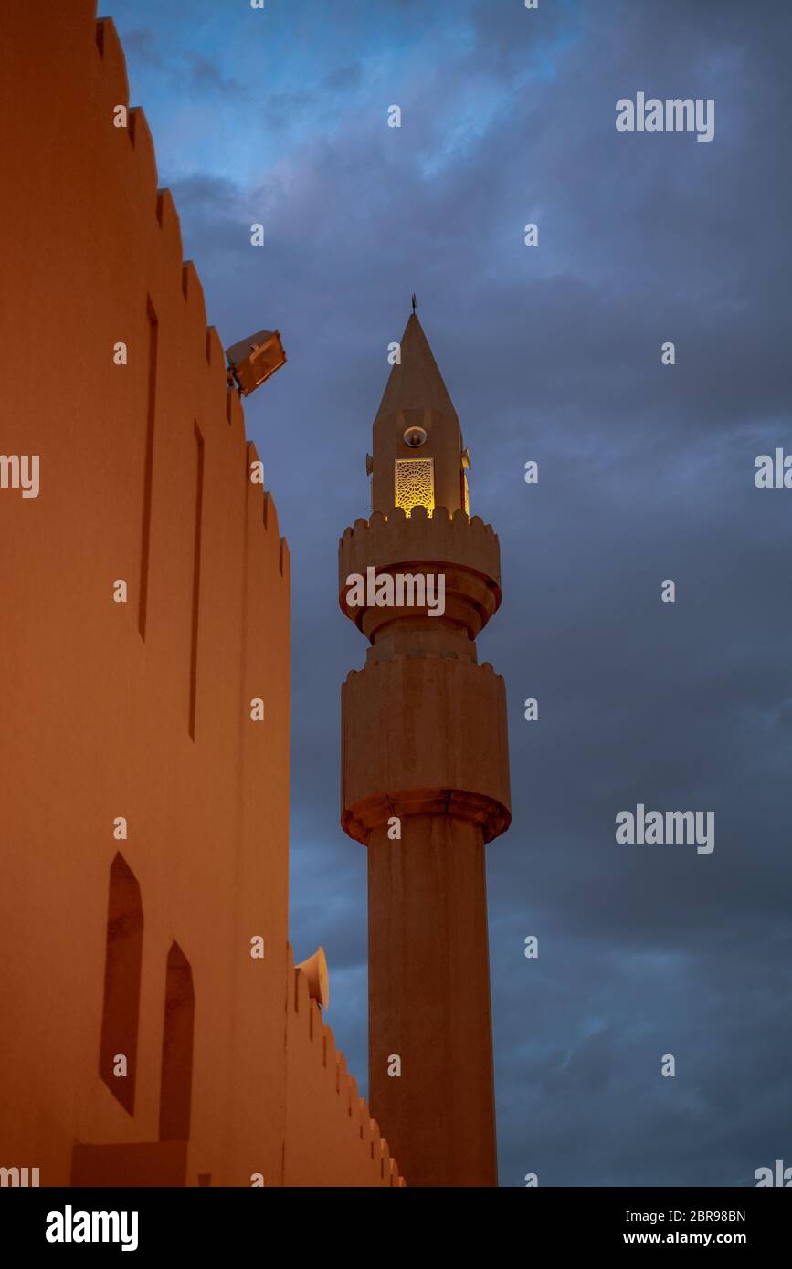 Muslim mosque minaret with dark cloud during the rainy day in Qatar Stock Photo