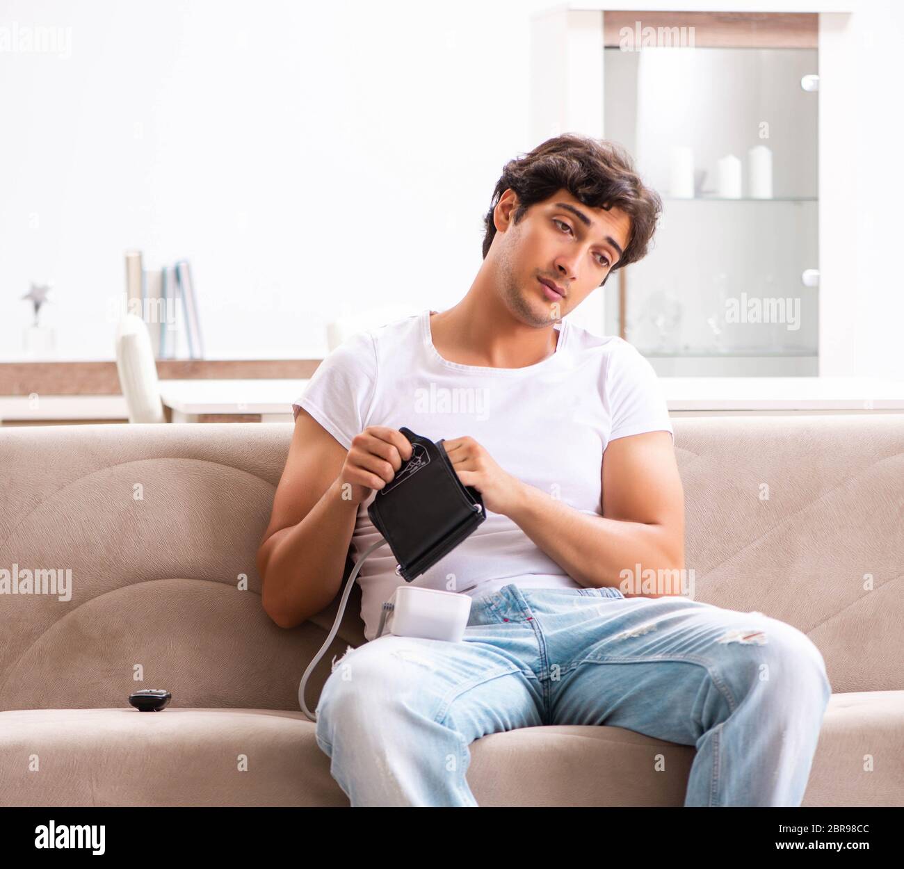 The young man measuring blood pressure at home Stock Photo - Alamy