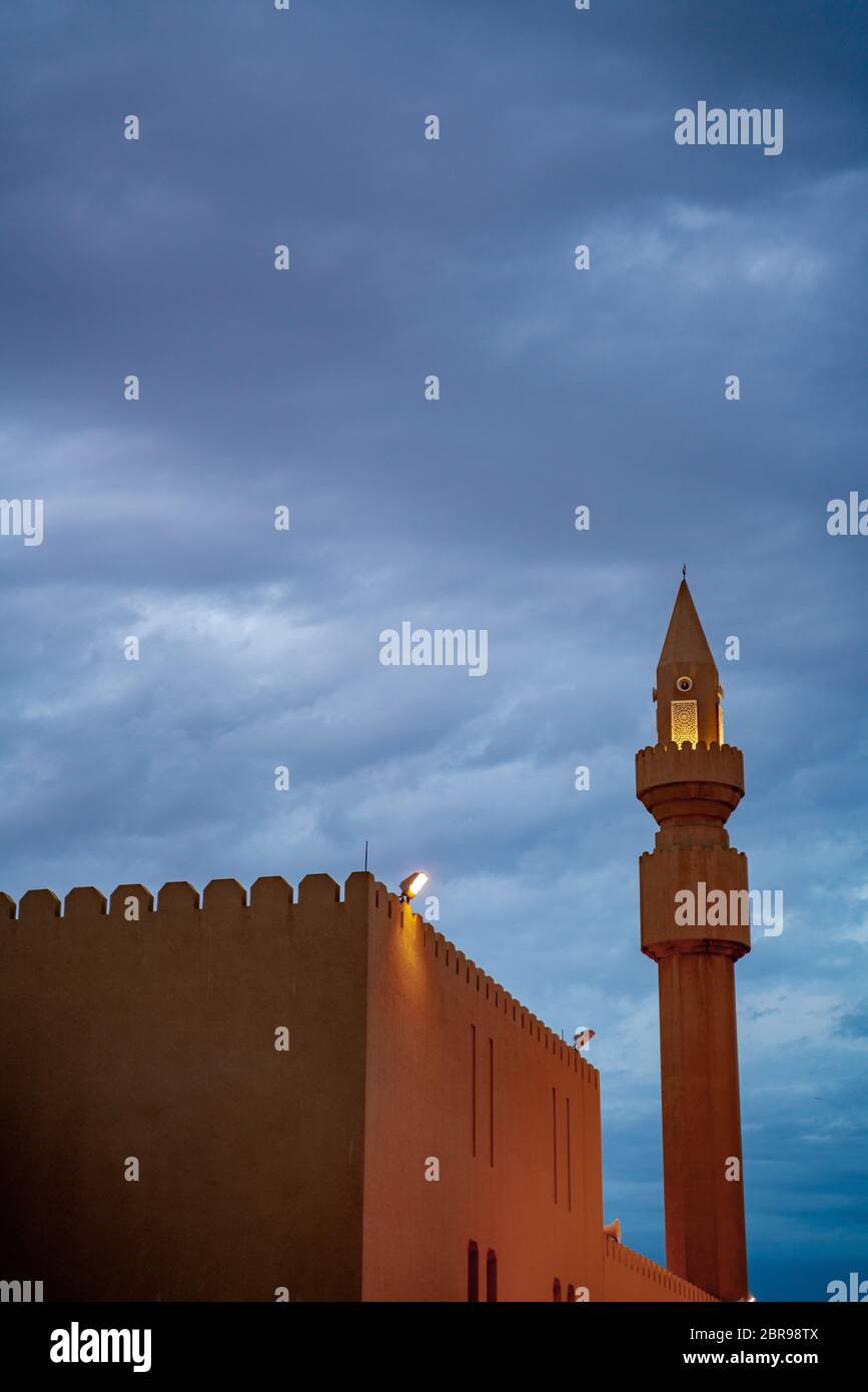 Muslim mosque minaret with dark cloud during the rainy day in Qatar Stock Photo
