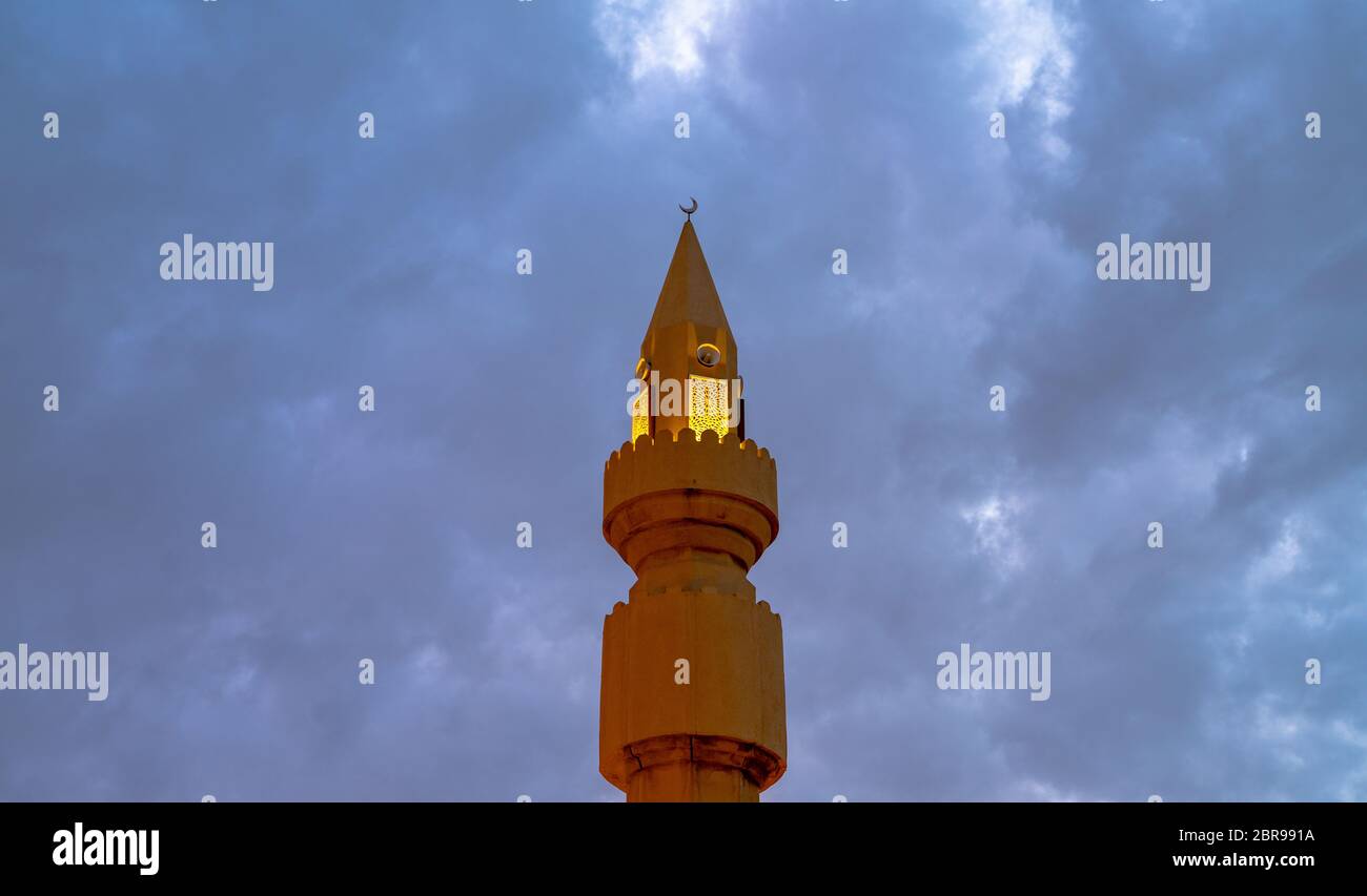 Muslim mosque minaret with dark cloud during the rainy day in Qatar Stock Photo