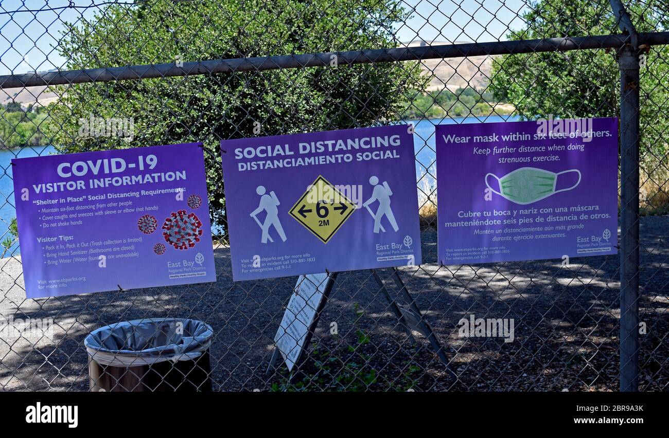 Covid-19 park visitor information signs about social distancing and wearing masks at Quarry Lakes Regional Recreation Area, Fremont, California Stock Photo
