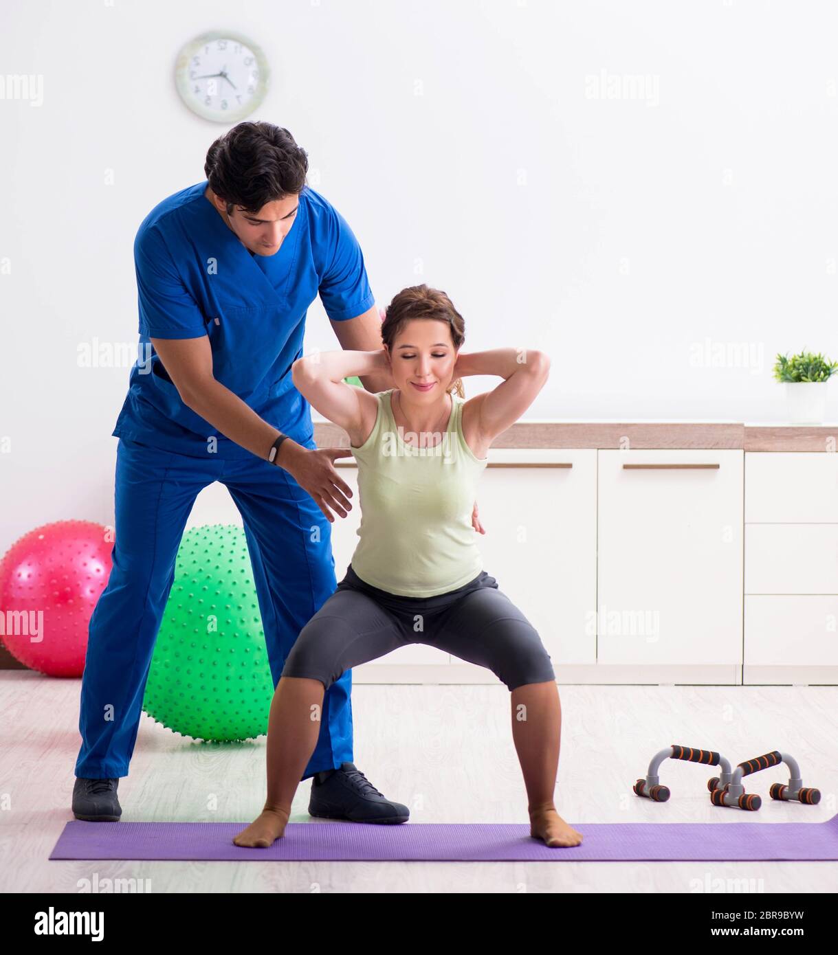 The fitness instructor helping sportsman during exercise Stock Photo ...