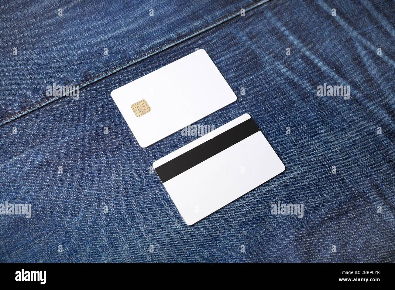 Blank chip cards on denim background. Two credit cards. Front and back view. Stock Photo
