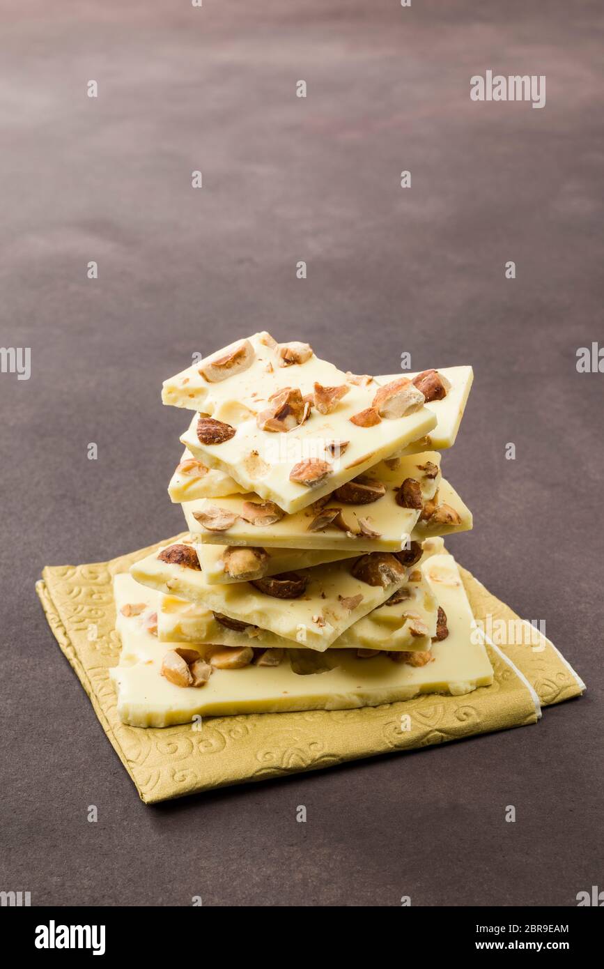hazelnut white chocolate pieces on brown background Stock Photo - Alamy
