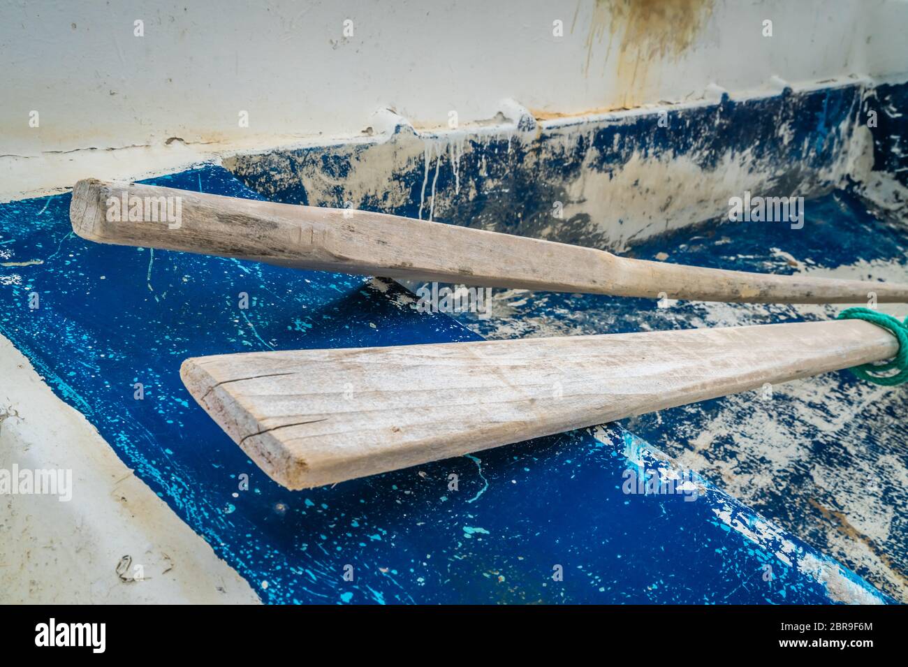 Wooden oars in an old, disused and abandoned rowing boat on the beach in Agios Nikolaos port in summer, Zante Island, Greece Stock Photo