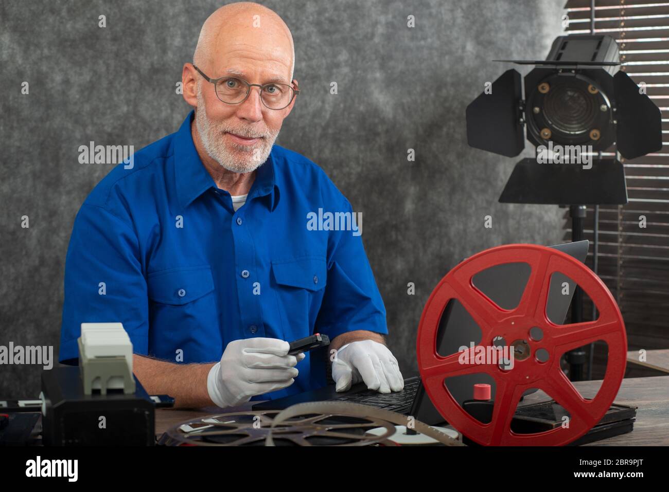 a technician with white gloves digitizing old film 16mm and DV Stock Photo