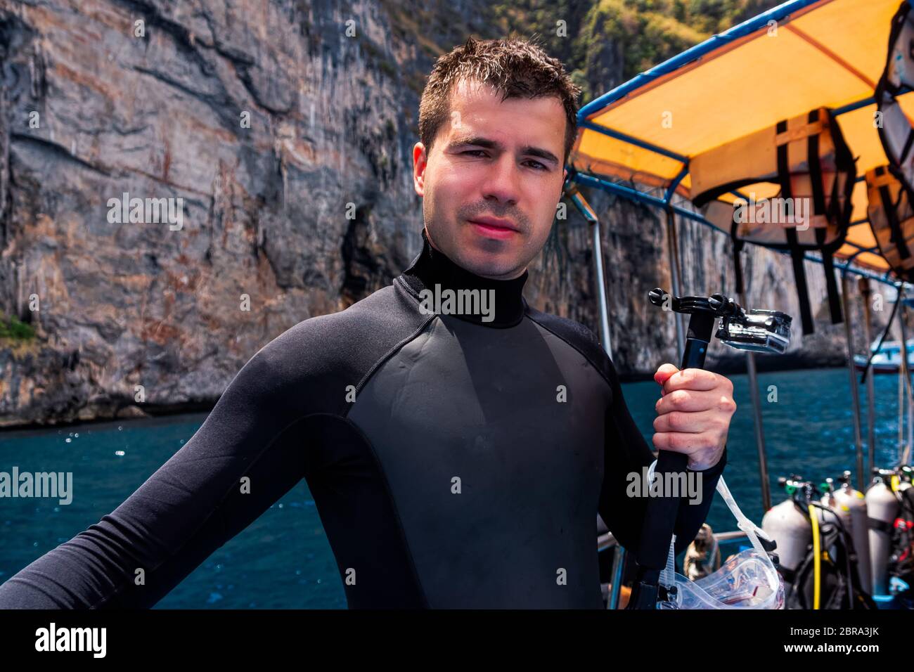 Young Caucasian male scuba diver holding action camera and preparing