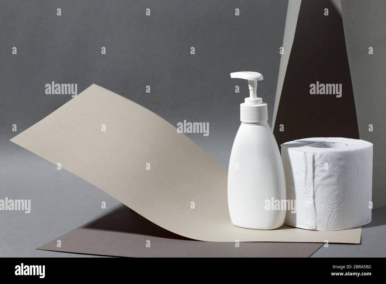 Set of toilet paper roll and liquid soap or sanitizer on matte gray.  Concept valuable actual goods, deficit in supermarkets, coronavirus  covid-19, pan Stock Photo - Alamy