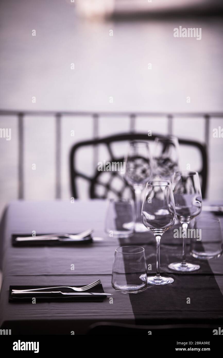 Empty glasses and dish ware on a table in a restaurant Stock Photo - Alamy