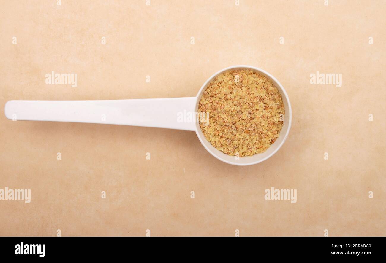 Wheat germs in measuring spoon on brown background Stock Photo