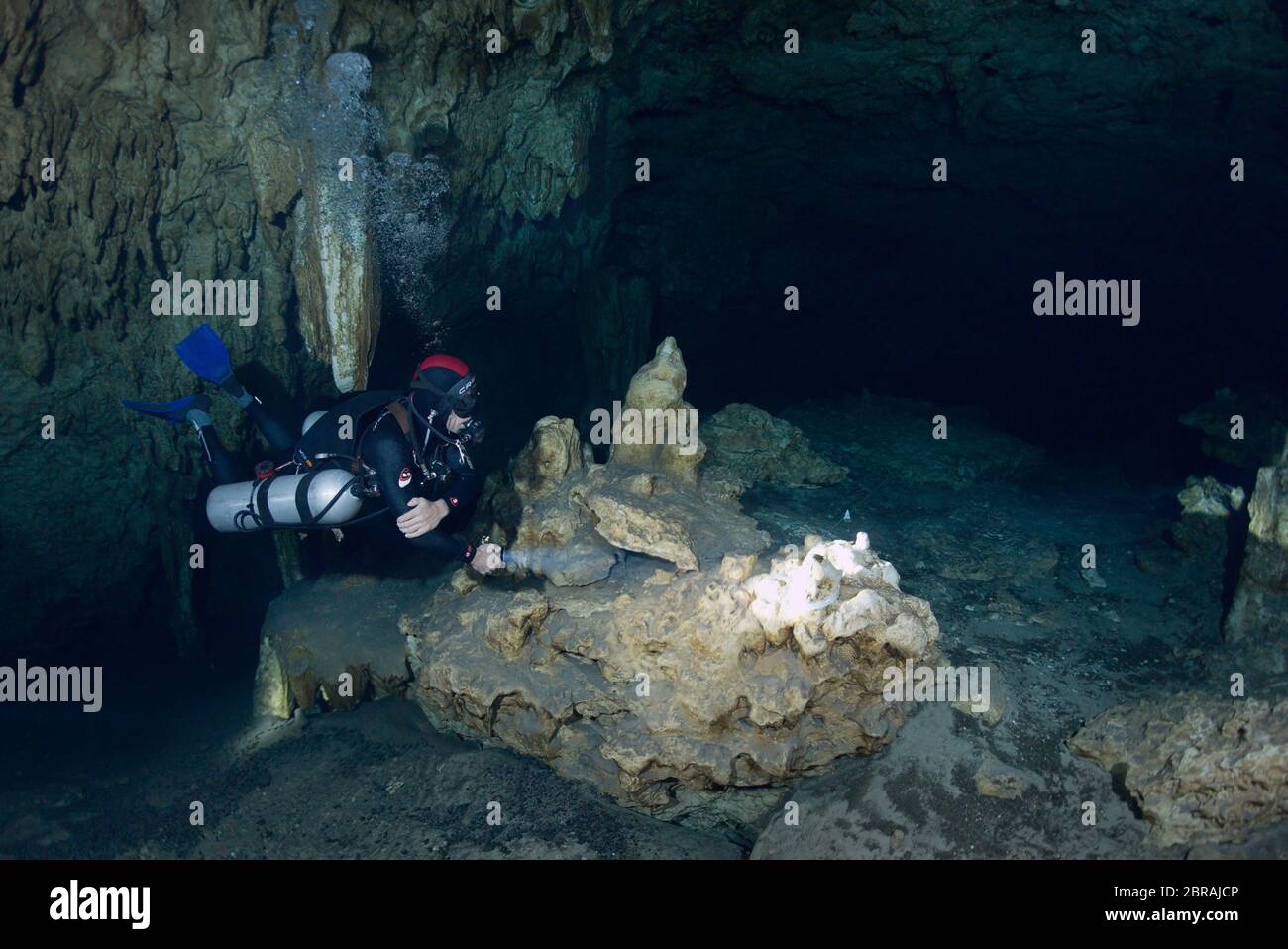 Sidemount technical diver with a torch in cenote  Car Wash near Tulum Stock Photo