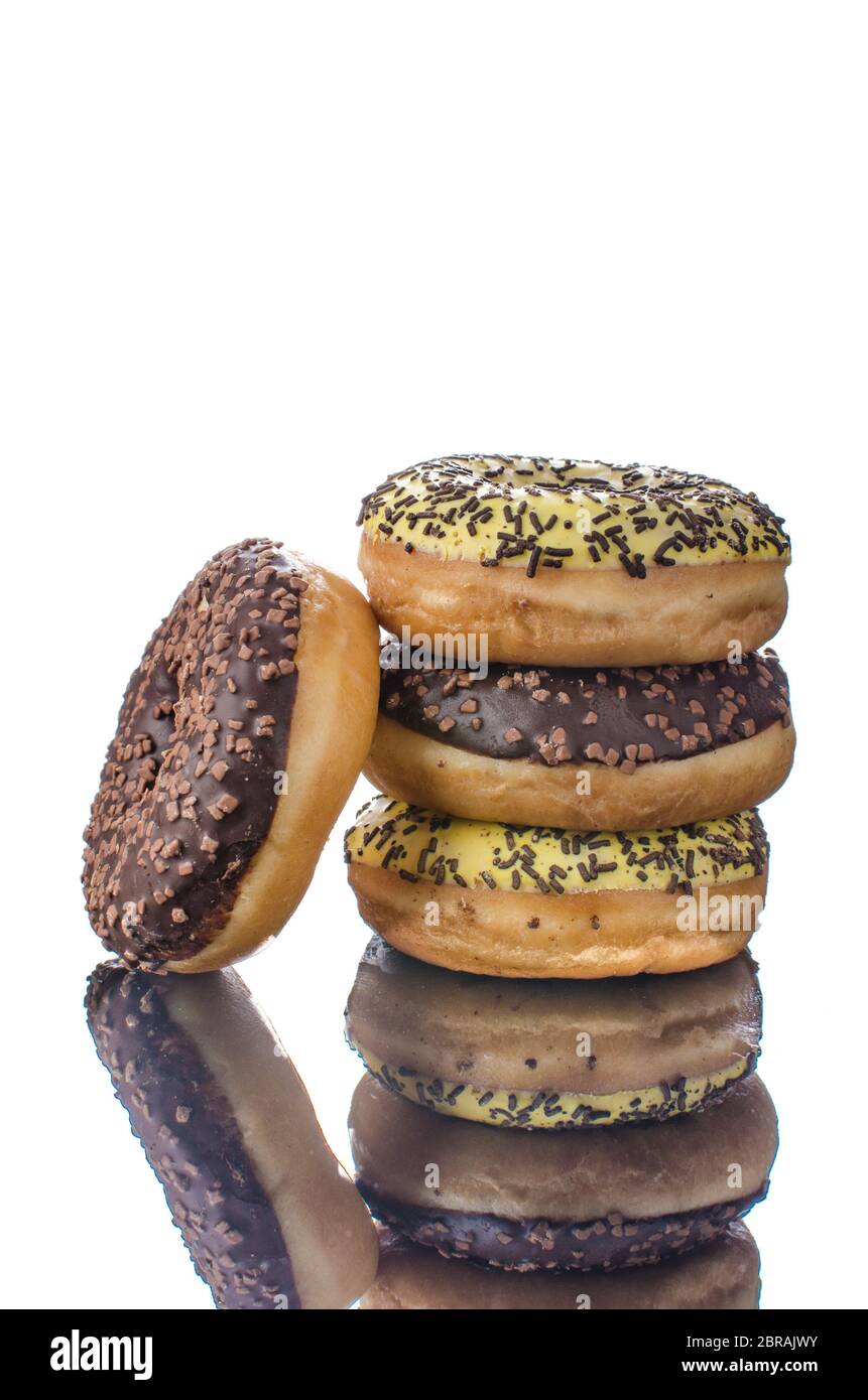Donuts on reflection table, white isolated, chocolate and banana donuts Stock Photo