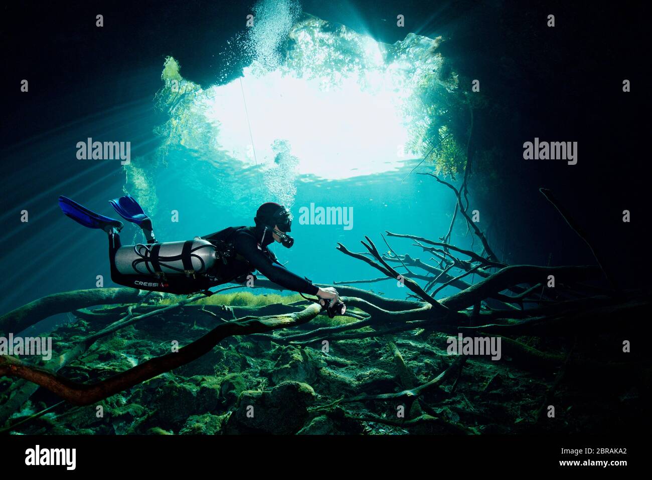 Sidemount technical diver with a torch in cenote  Car Wash near Tulum Stock Photo