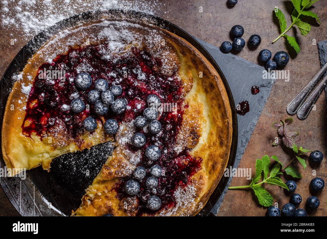 https://c8.alamy.com/comp/2BRAKB3/dutch-style-pancake-named-dutch-baby-baked-in-oven-on-iron-skillet-best-pancake!-with-forest-fruit-and-jam-2BRAKB3.jpg