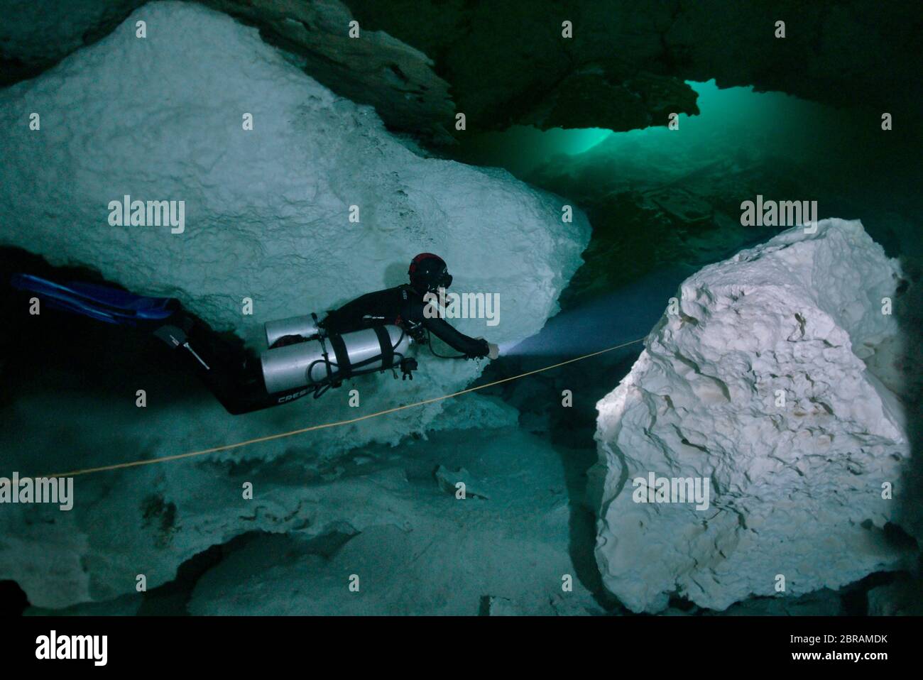 Technical sidemount diver on the cenote Calavera, know as the Temple of Doom with a strong halocline. Stock Photo