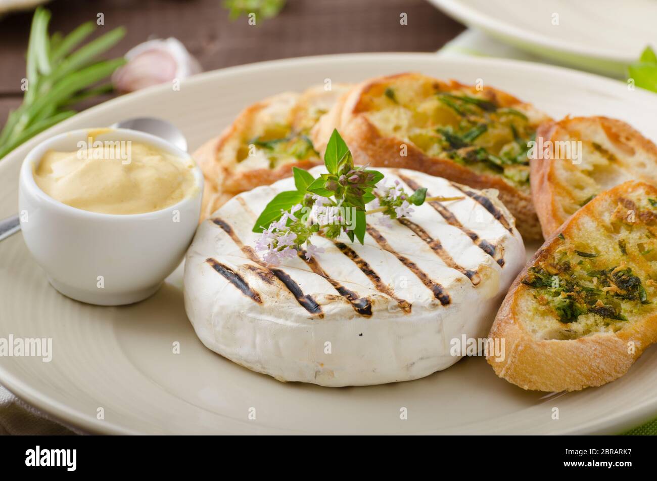 Grilled camembert with Dijon mustard and herbs baguettes Stock Photo