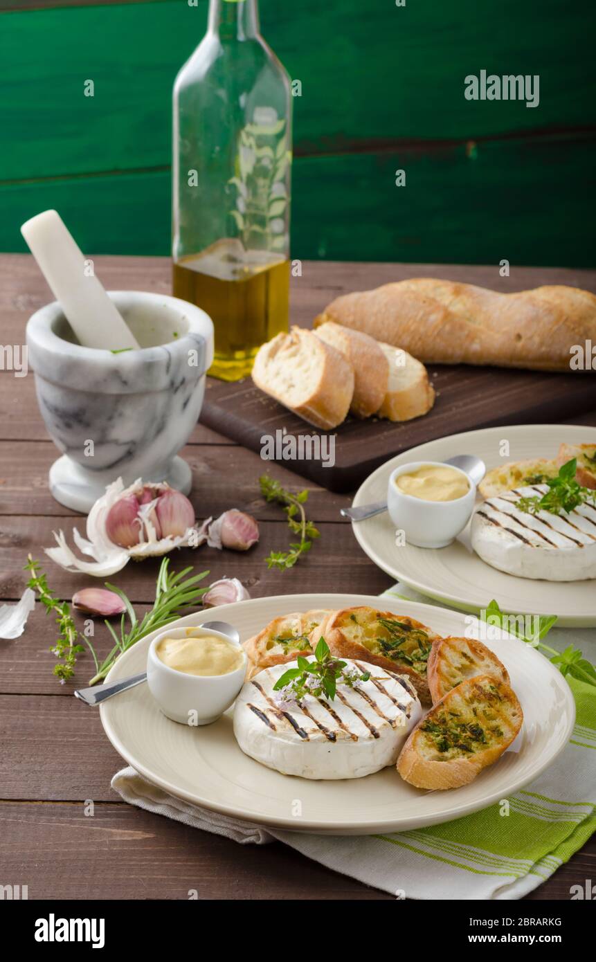 Grilled camembert with Dijon mustard and herbs baguettes Stock Photo
