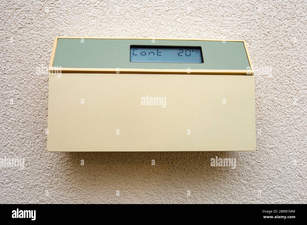 Hand press indoor room thermostat to lower the temp, Stock image