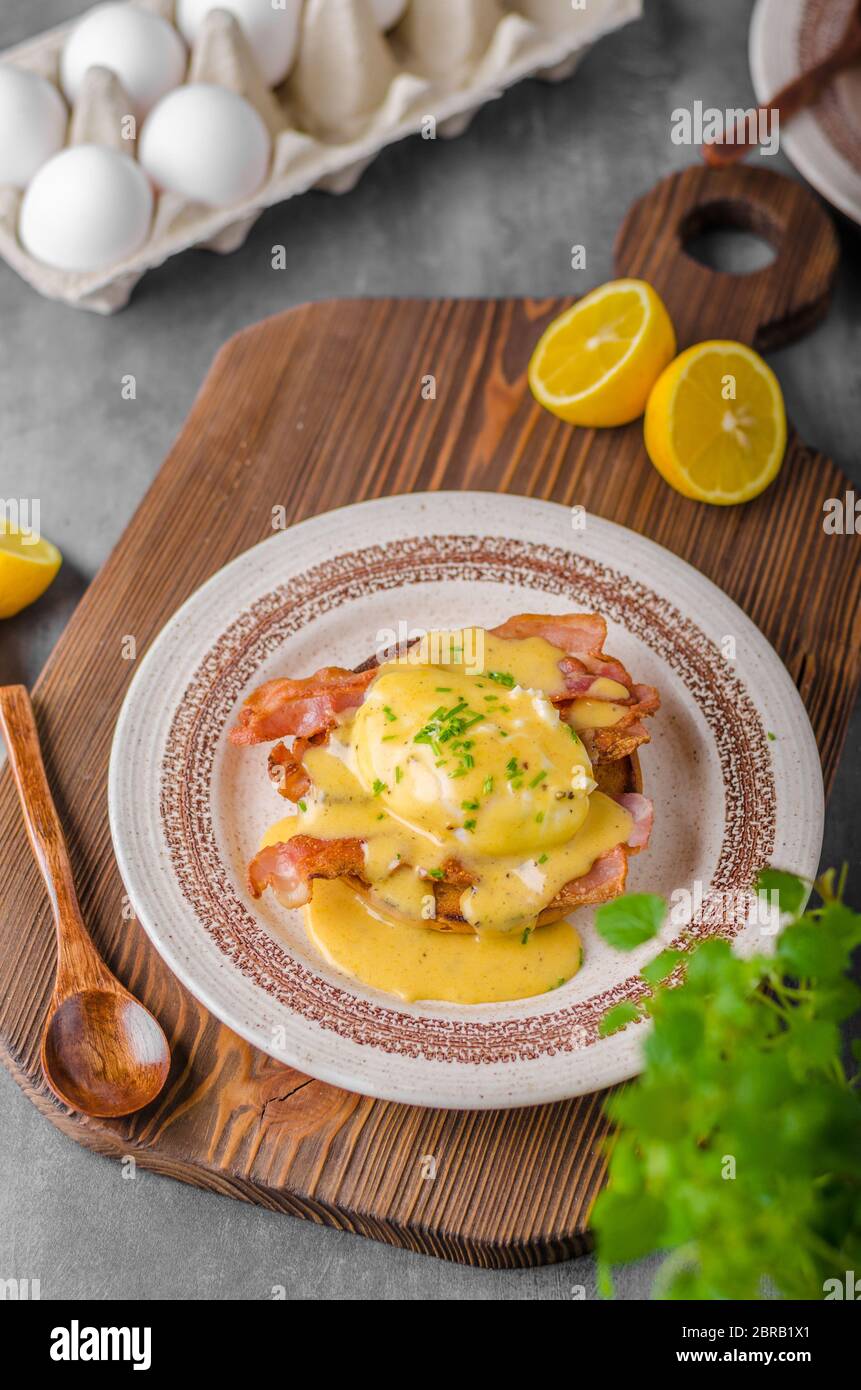 Eggs benedict with bacon, hollandaise sauce, delish food Stock Photo