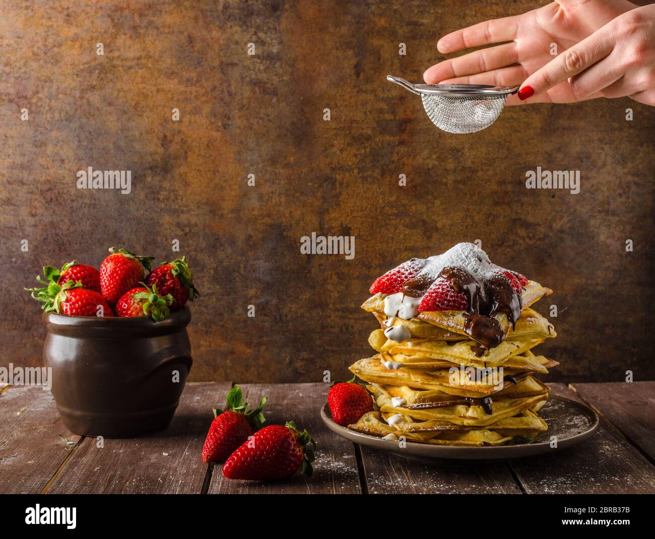 The original Belgian waffles with strawberries, chocolate and sprinkled with sugar Stock Photo