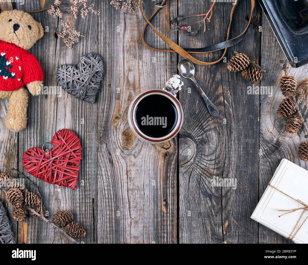 ceramic cup with black coffee and a little teddy bear in a red sweater
