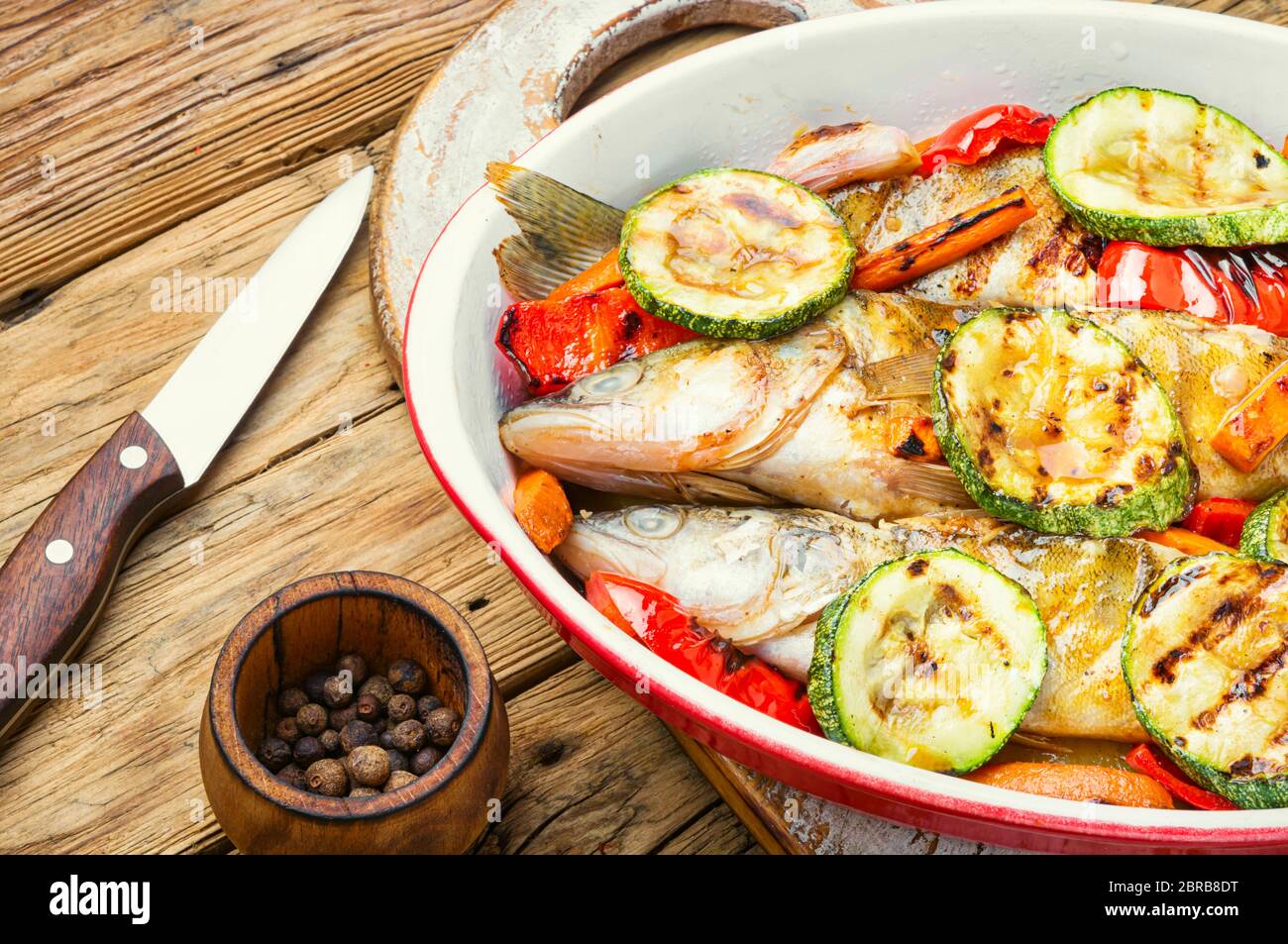 Baked fish with vegetable garnish.Baked pike perch with zucchini and