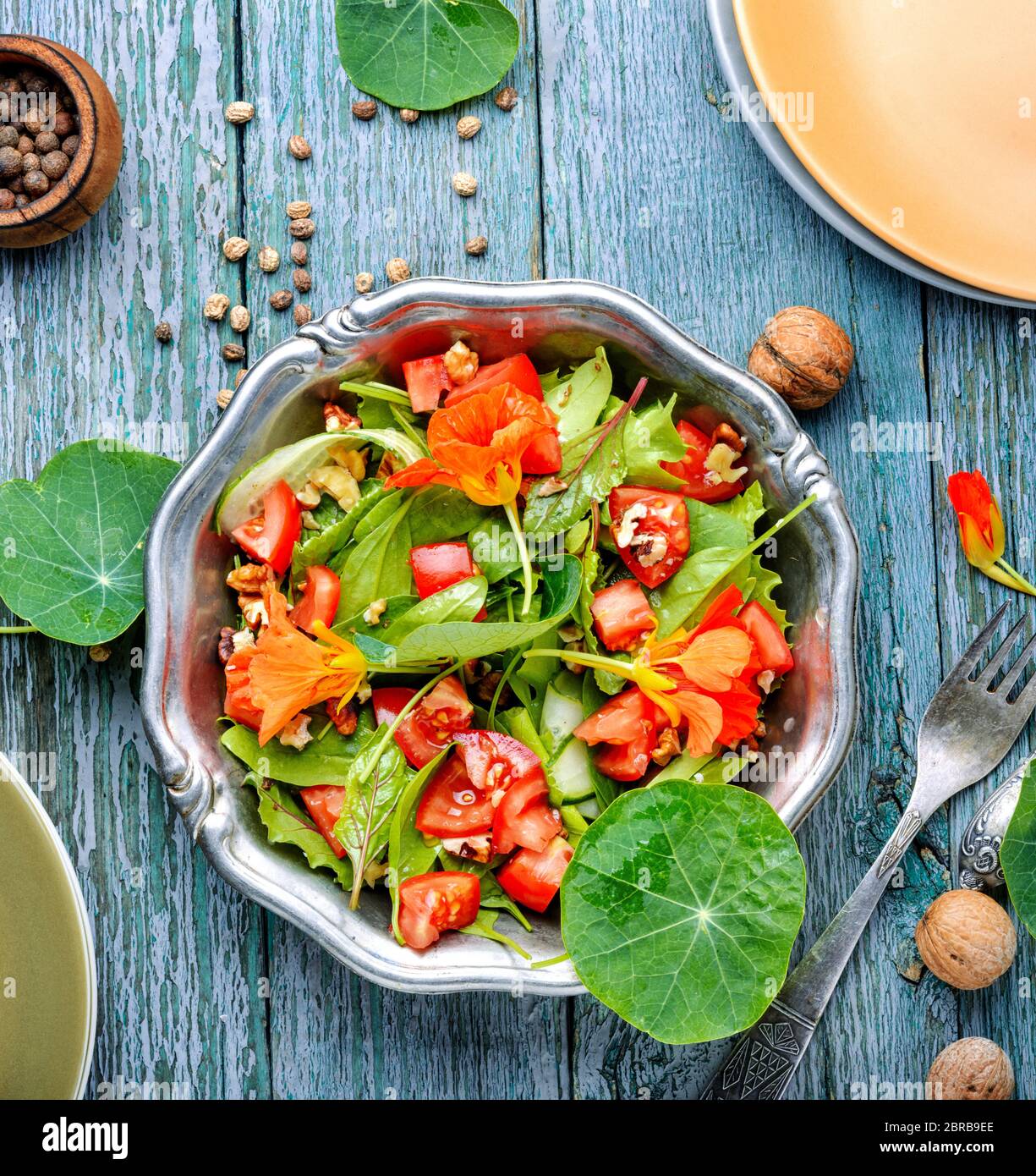 Healthy salad with flowers, nasturtium leaves, tomatoes and nuts. Indian salad.Diet food Stock Photo