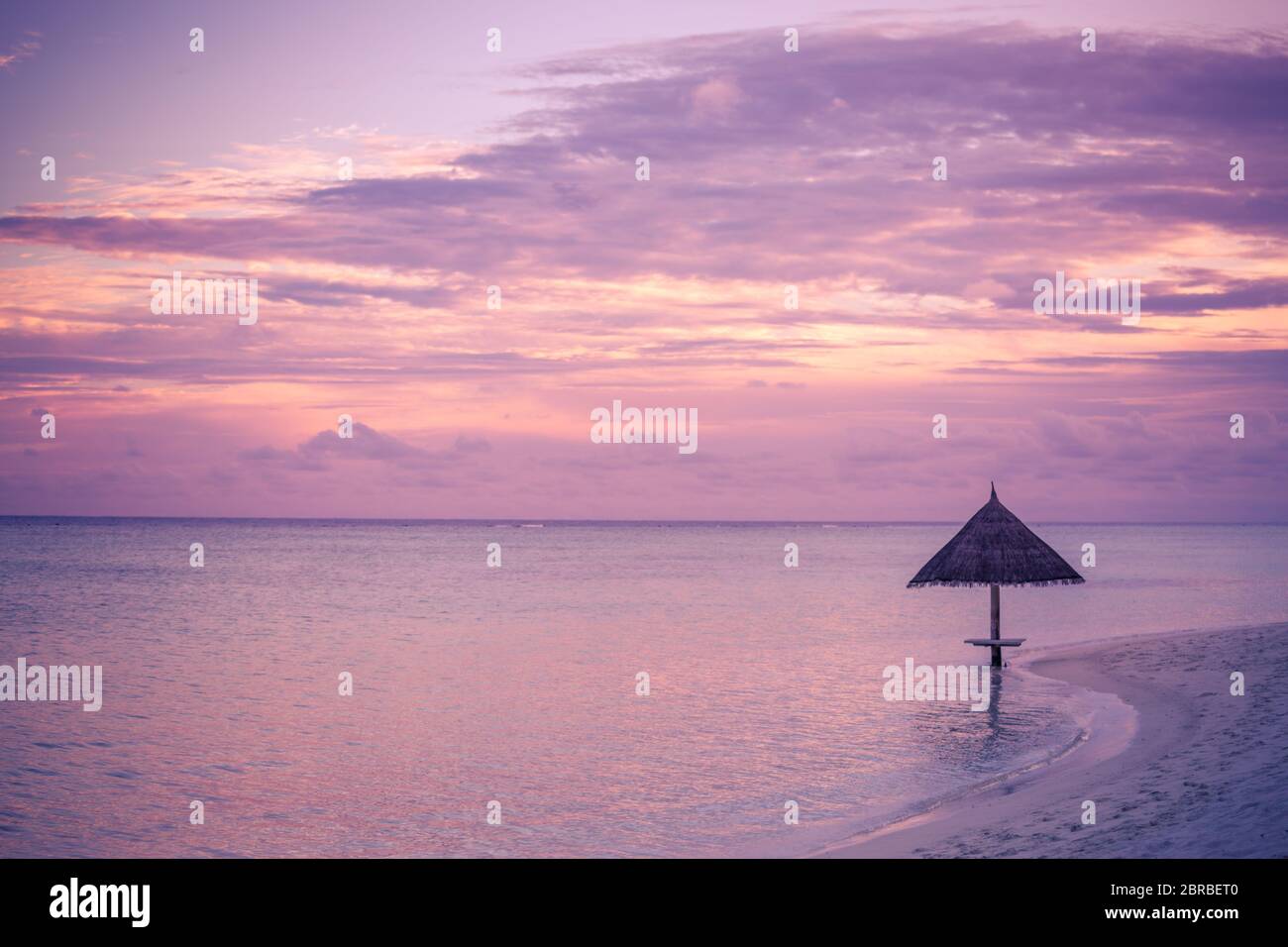 Sea sunset and wooden parasol on the beach, colorful sky and seascape Stock Photo