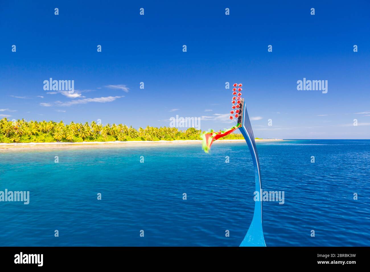 View from the deck of the traditional Maldivian wooden fishing boats on landscape of tropical island with a sandy beach and palm trees Stock Photo