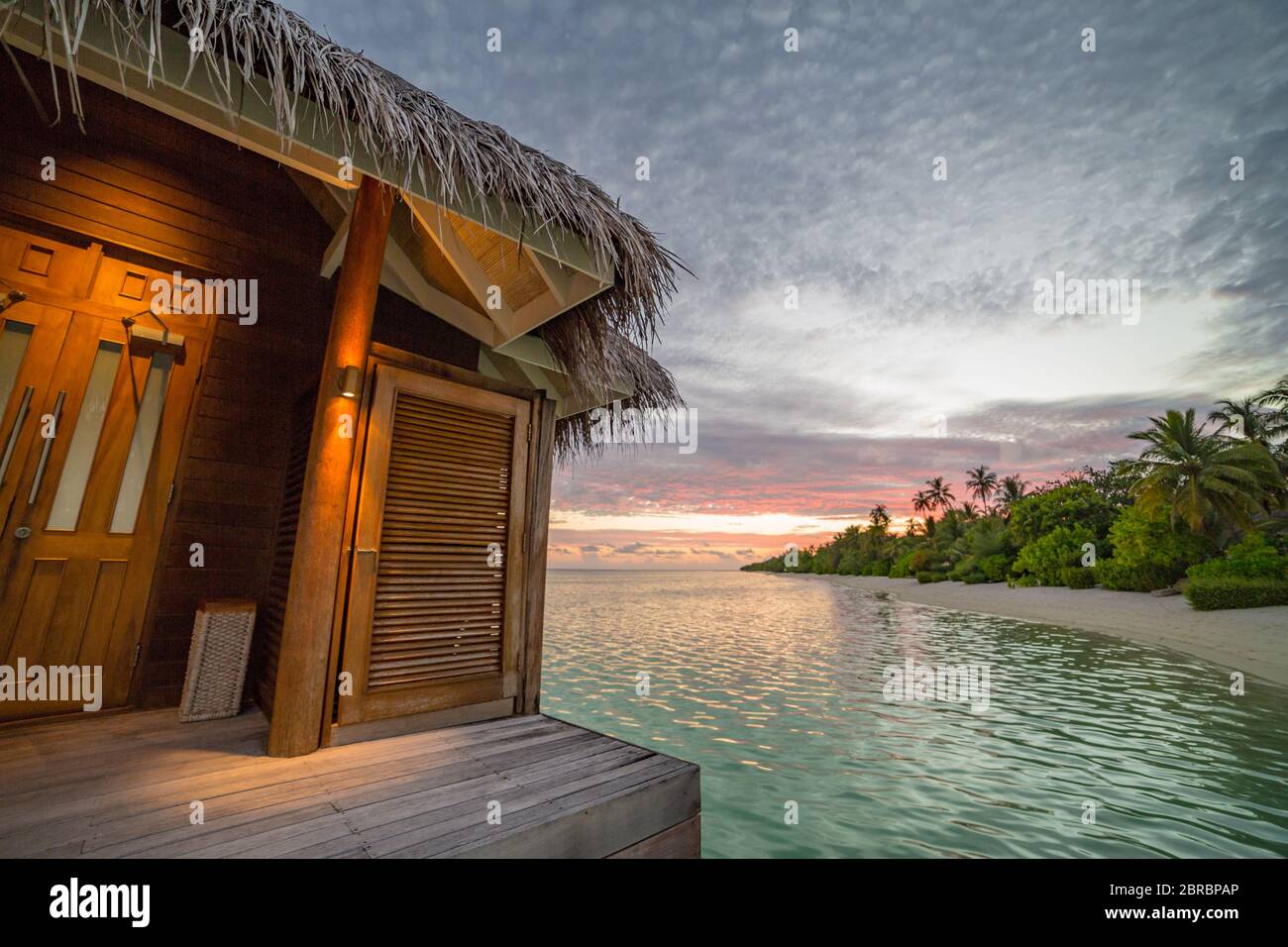 Beautiful isolated luxury water bungalows, sunset view Maldives in the blue green ocean of the Maldives. Luxury travel landscape Stock Photo