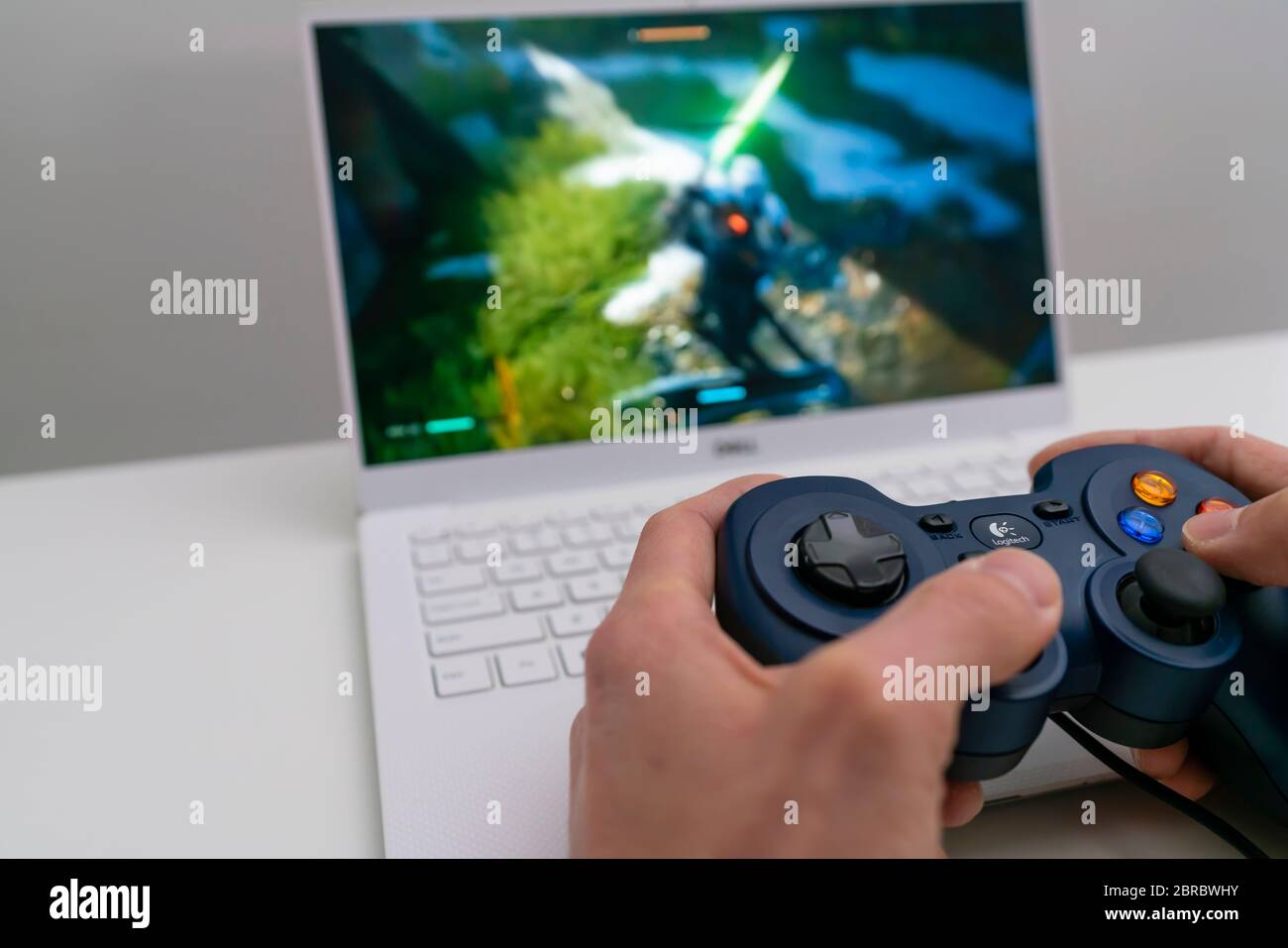 Playing game on laptop computer with joypad Stock Photo