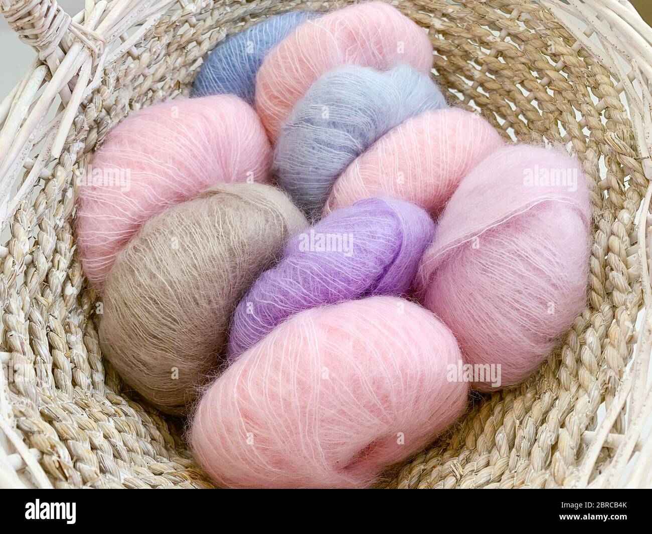 colored balls of wool yarn in wicker basket Stock Photo