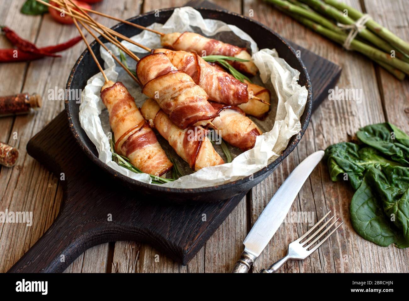 Roll with bacon and chicken mince on a stew with fresh asparagus and spices Stock Photo Alamy