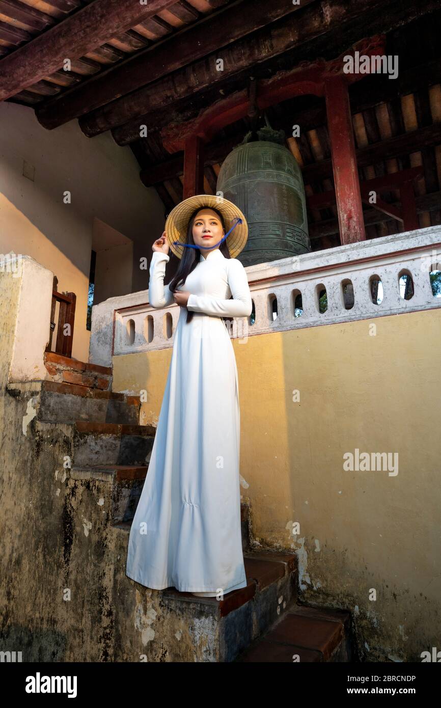 Hue City, Thua Thien Hue Province, Vietnam - May 7, 2020: Photo of a girl in a traditional ao dai costume inside a temple in Hue City, Thua Thien Hue Stock Photo